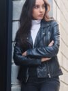 beautiful-young-woman-leather-jacket-standing-near-wall-with-her-arms-crossed